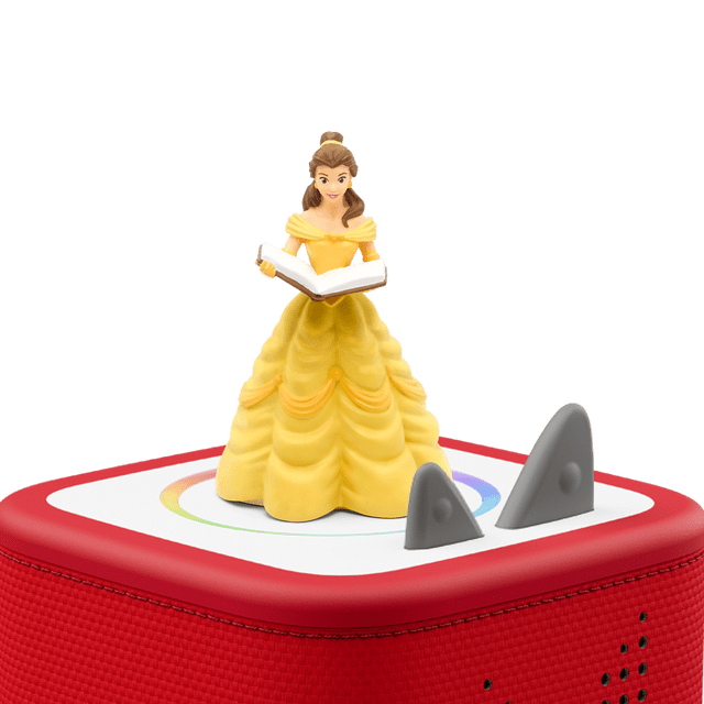 Tonies FRENCH - Beauty and the Beast/La Belle Et la Bete figurine showing Belle in a yellow ball gown holding an open book, standing on a red Toniebox speaker with fabric covering and gray control ears, designed for screen-free French educational audio play for children.