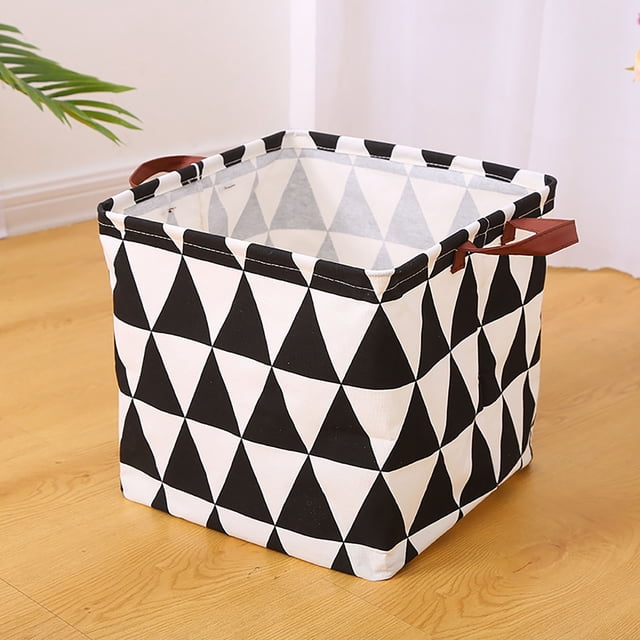 TopLLC Laundry Basket Dorm Baby Laundry Basket Large Laundry Hamper with Handle for Dirty Clothes. A foldable, square-shaped fabric laundry basket with a black and white geometric triangle pattern, featuring sturdy brown handles on both sides. Suitable for storing dirty clothes, toys, or miscellaneous items. The basket is placed on a wooden floor in a bright indoor setting.
