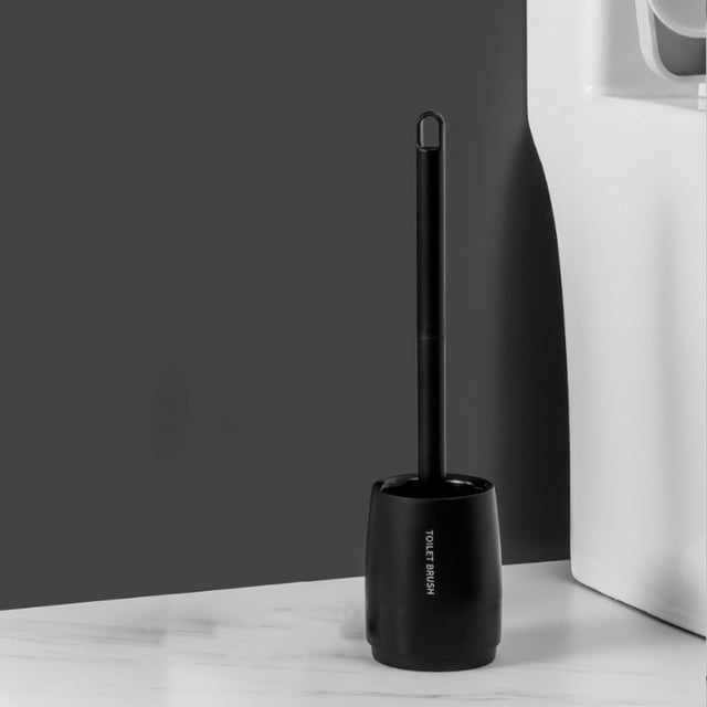 LSLJS Brosse de Toilette à Poils Durs, Ensemble de Brosse pour Cuvette de Salle de Bain, au design Moderne et compact en Plastique Noir. la Brosse a un long Manche et une base Robuste pour la Stabilité, Idéale pour un Nettoyage Efficace des Toilettes, Y Compris les Rainures. la Brosse Est Présentée dans un Support Noir Élégant sur un Comptoir Blanc avec un Fond Gris.