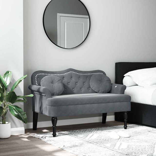 vidaXL Bench with Cushions in dark grey velvet, measuring 120.5x65x75 cm, designed for entryway furniture. Features button tufting, rolled armrests, antique-style wooden legs, and two round cushions. Thickly padded seat ensures comfort. Displayed in a modern bedroom with a circular mirror and indoor plant.