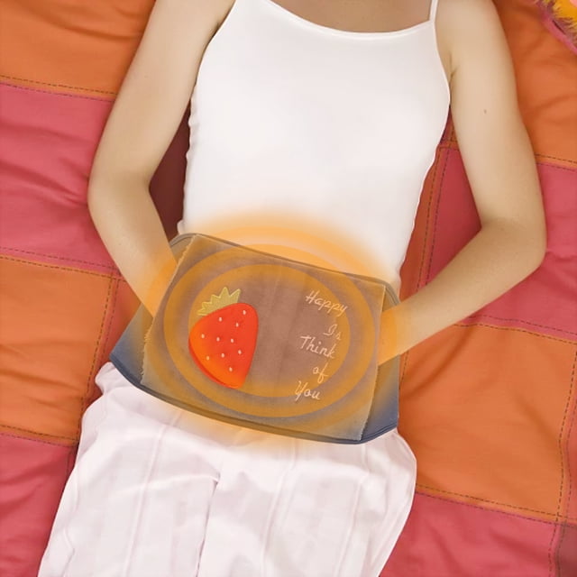 Wzzjkit Heating Pad for Period Cramps shown in use, wrapped around the waist of a person lying on a bed. The grey heating pad features a strawberry design and the text 'Happy I Think of You' embroidered on the surface. The pad emits a warm glow, indicating active heating. Made of soft corduroy, it provides comfort and warmth for menstrual cramps, lower back pain, and cold weather activities. Suitable for indoor and outdoor use, including camping and travel.