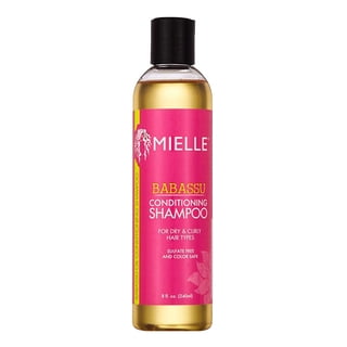 Mielle Organics Babassu Conditioning Sulfate Free Shampoo in an 8 fl oz bottle. The shampoo is designed for dry and curly hair types, featuring organic ingredients like babassu oil, almond protein, and hibiscus extract to cleanse, moisturize, and strengthen hair. The bottle has a vibrant pink label with white and gold accents, and a black flip-top cap.