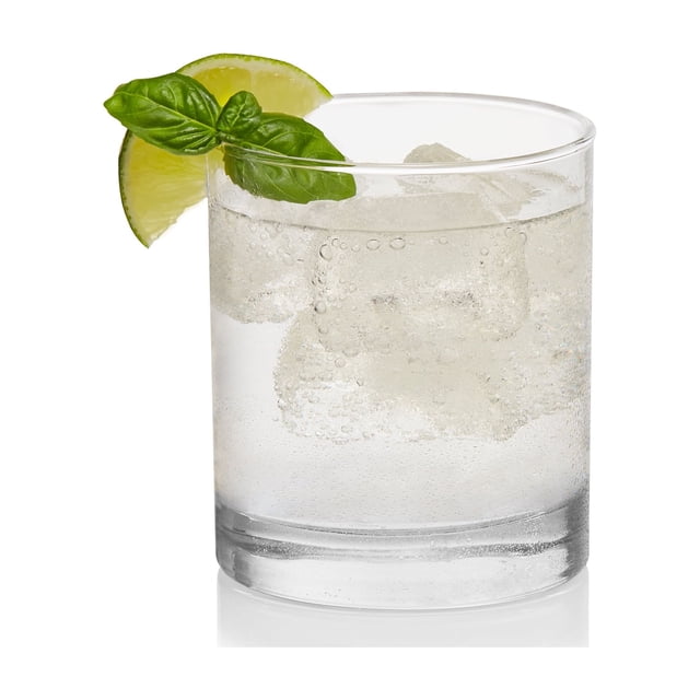 Province Verre Double à l'Ancienne Tenant de l'Eau Pétillante Claire avec des Glaçons, Garni d'Un Quartier lime et d'Une Feuille de Basilic Fraîche sur le Rebord, Conçu avec une Esthétique Minimaliste Idéale pour Manger et Recevoir des Verres.