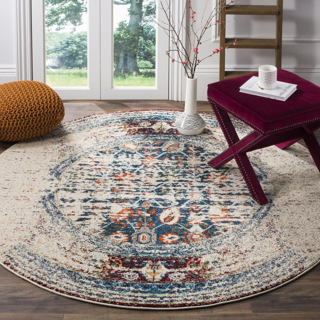 Safavieh Monaco Tapis Vintage Annabelle, Rond avec un Motif Persan Vieilli en Tons Bleu, Rouille et Crème, Tissé Mécaniquement en Polypropylène durable, Exposé sur un Plancher de Bois Franc Près d'Une Porte en Verre, Style avec un Tabouret en Velours Bourgogne, un vase Blanc avec des branches Florissantes et un pouf orange Tricoté, Idéal pour Ajouter une Touche Bohème-Chic aux Intérieurs de la Maison.