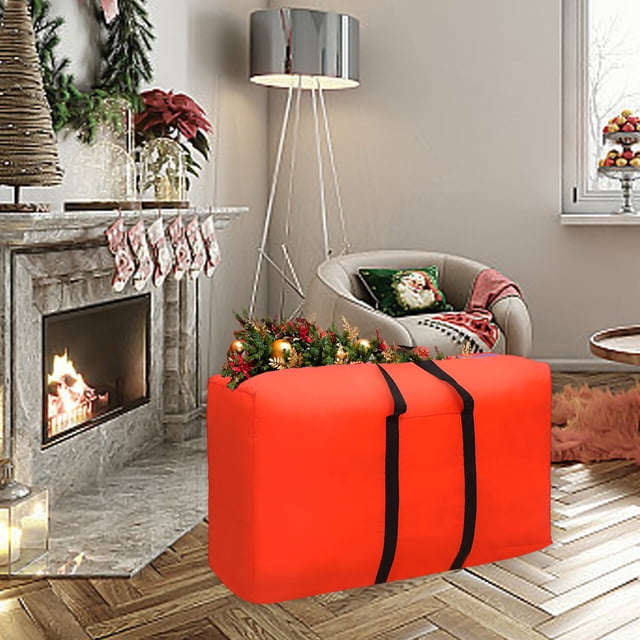 Wzzjkit Christmas Tree Storage Bag in bright orange, crafted from durable 600D Oxford cloth with reinforced handles and sturdy zippers. The bag, with a 100L capacity, is displayed in a festive living room setting, filled with artificial Christmas tree decorations. Ideal for holiday storage, it accommodates comforters, blankets, pillows, and seasonal items, offering a foldable design for space-saving organization.