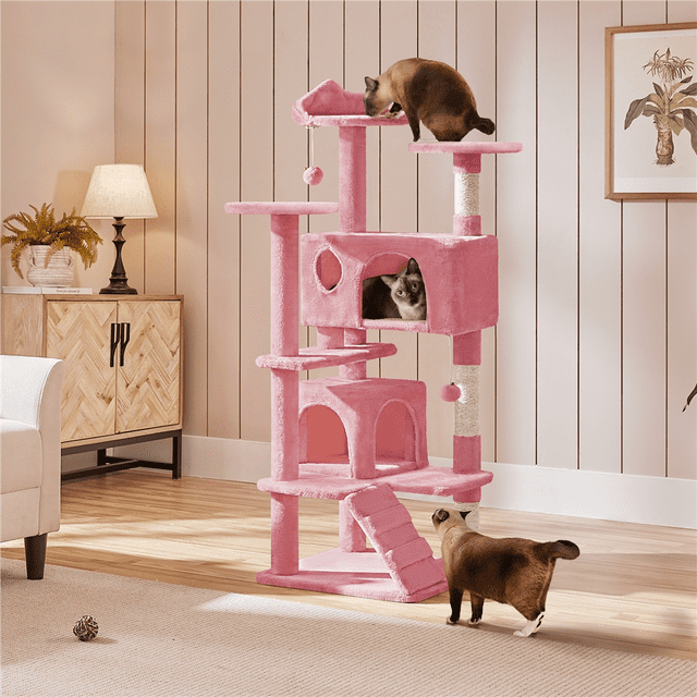 Yaheetech Arbre à Chat de 54 Po avec 3 Poteaux à Griffer Rose, Grand Arbre à Chat Conçu pour 2-3 Chatons. Comprend des Niveaux à Plusieurs Niveaux avec Deux condos Fermés, Trois Perchoirs Supérieurs, des Poteaux à Griffer en Corde de sisal et des Balles Pendantes pour Jouer. Fabriqué en Panneau de Particules et en Matériau Peluche, Comprend une Sangle de Sécurité pour la Stabilité. Idéal pour Offrir aux Chats un Espace Sûr et Divertissant. Positionné dans un Coin de Salon Douillet avec des Chats Explorant Activement la structure.