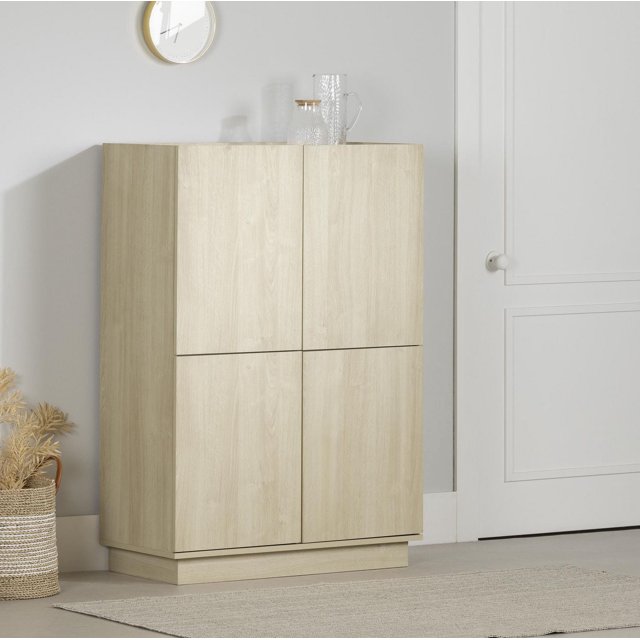 South Shore Arum High-Buffet Cabinet in bleached oak with four handleless push-to-open doors and a recessed podium base, featuring adjustable shelves for versatile dining room storage, shown against a light grey wall with a white door and decorative glassware on top, also suitable as a refined sideboard.