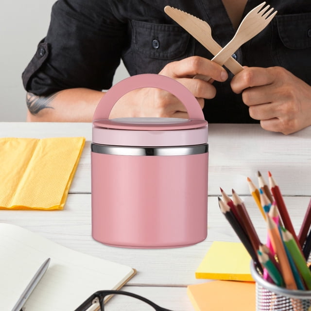 WRXMIJNHGSA Boîte à Lunch Isotherme pour Aliments, Contenant Alimentaire en Acier Inoxydable Rose avec Grand Ouverture et Poignée Robuste. le Contenant Est Isolé sous Vide, Idéal pour Garder les Aliments Chauds Ou Chauds, et a une Capacité de 630 ml. Il Est Montré sur un Bureau Blanc avec de la Papeterie et une Personne Tenant des Ustensiles en Bois en Arrière-Plan.