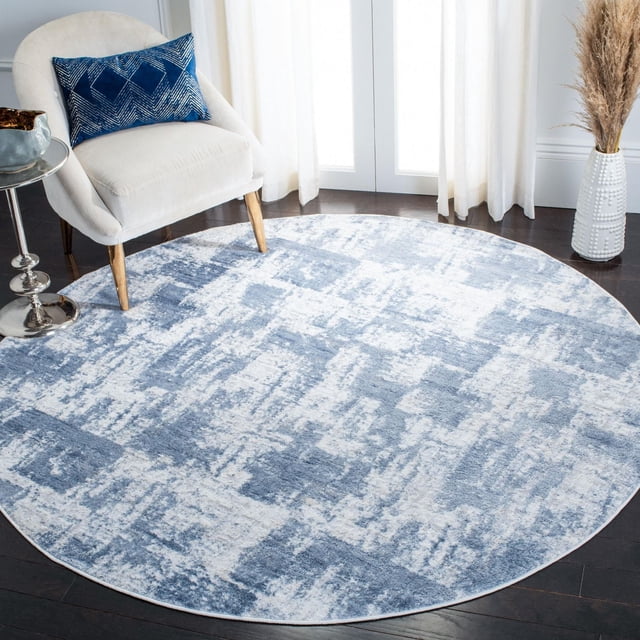 Safavieh Amelia Carrie Tapis Abstrait Usé, Rond avec un Motif Abstrait Usé Bleu et Blanc, sur Plancher de Bois Franc Foncé dans une Pièce Lumineuse avec un Fauteuil beige avec des Pieds en Bois et un Coussin Géométrique Bleu, une table d'Appoint Chromée, et un vase Texturé Blanc avec de l'Herbe de la Pampa Séchée, Idéal pour Accentuer les Salons Ou les Chambres.