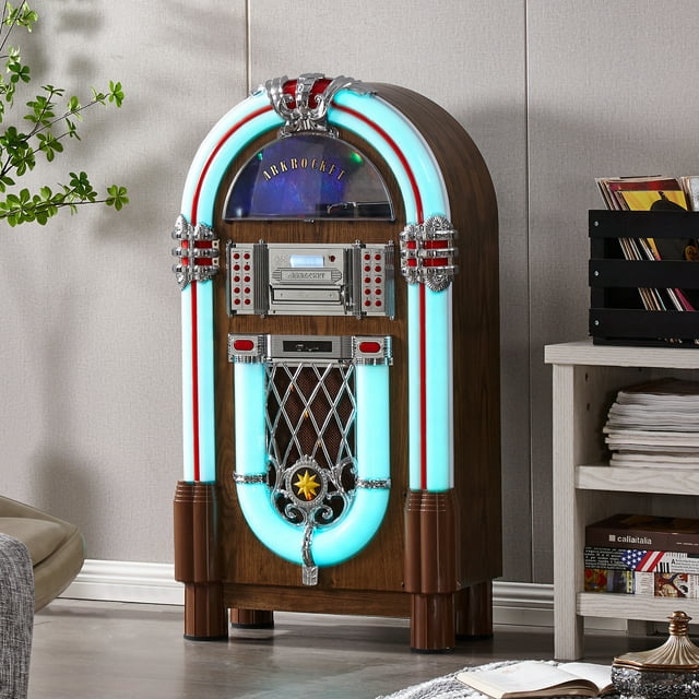 Arkrocket Taurus II Jukebox Tourne-Disque Vinyle Bluetooth USB Lecteur CD Radio Rétro Jukebox en Fini Chêne Foncé. le Jukebox de Taille Moyenne Présente un design Inspiré des Années 1950 avec Panneaux Illuminés, accents Chromés et une Tourne-Disque à Entraînement par Courroie avec Arrêt Automatique. Il Comprend un port USB, Lecteur CD Compatible MP3, Fente SD, Connectivité Bluetooth 4.0, Radio FM avec Mémoire pour 20 stations, Entrée AUX et Sortie Ligne RCA. Dimensions : 41 x 22 x 12 Pouces. Présenté