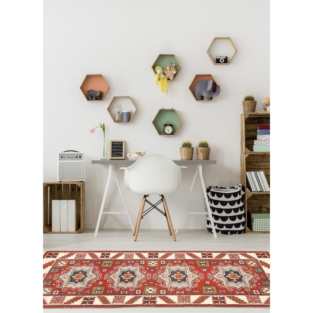 ECARPETGALLERY 100% Wool Traditional Indoor Area Rug for Entrance, Bedroom, Living Room and Dining Room with bold geometric Persian Kazak-inspired patterns in red, beige, and blue tones, displayed in a minimalist room with a white chair, gray desk, hexagonal wooden wall shelves holding plush toys and decor, wooden crates, and potted cacti, ideal for adding warmth and style to living spaces.