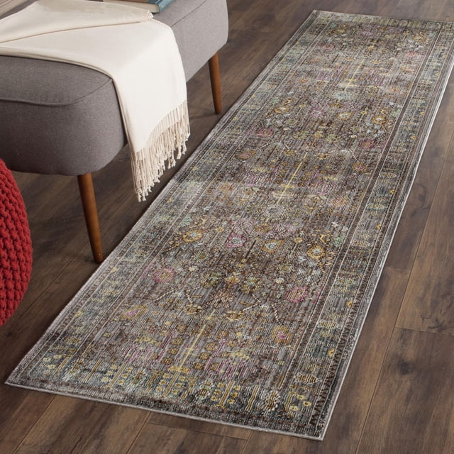 Safavieh Valencia Grigor Traditional Area Rug runner featuring a traditional over-dyed design in muted brown, pink, yellow, and blue tones with serged edges, placed on dark hardwood flooring beside a gray bench with wooden legs and a cream throw, ideal for adding warmth and style to narrow hallways or entryways.