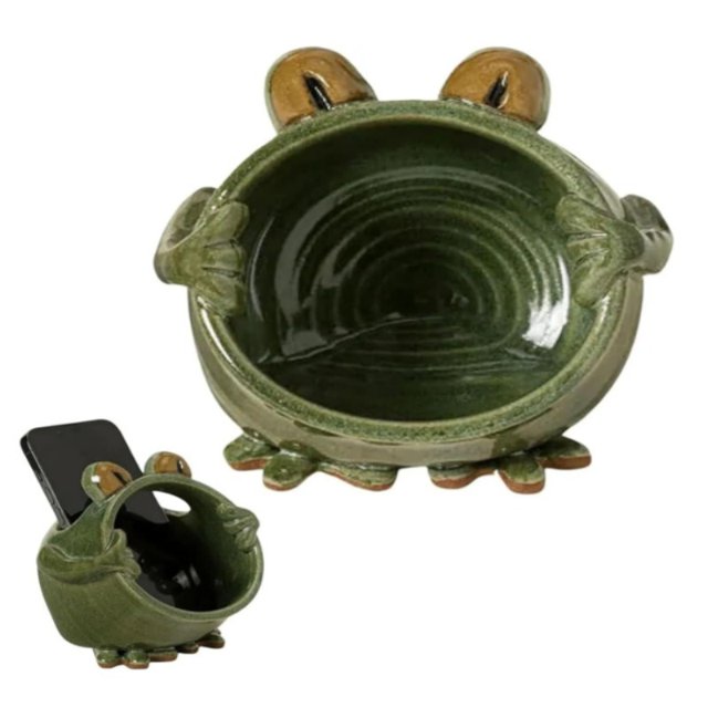 JIWULIASDCA Mini Megaphone Ceramic Phone Amplifier with a frog design, featuring a handcrafted green ceramic body with a slot on the frog's head for smartphone placement. The amplifier enhances sound by 10 decibels using pure ceramic technology, requiring no batteries or cables. Compatible with various smartphone sizes, it doubles as a decorative stand for hands-free use, ideal for video calls, reading, or watching videos. The frog's mouth acts as a natural megaphone, amplifying sound waves effectively.