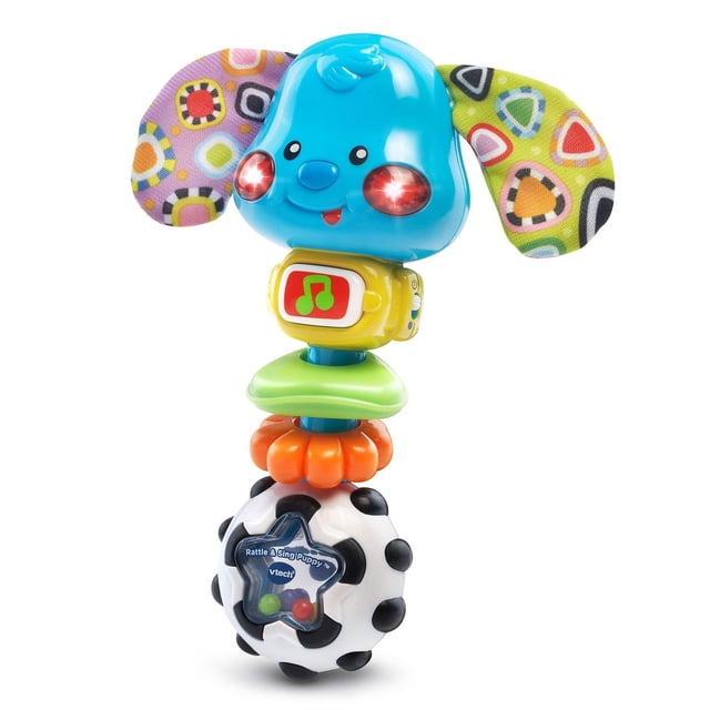 VTech Rattle & Sing Puppy™ baby rattle with a blue puppy head that lights up red cheeks, colorful crinkly fabric ears, a yellow music button with a green musical note, two textured rings for motor skills, and a black-and-white ball base with colorful beads for sensory play.