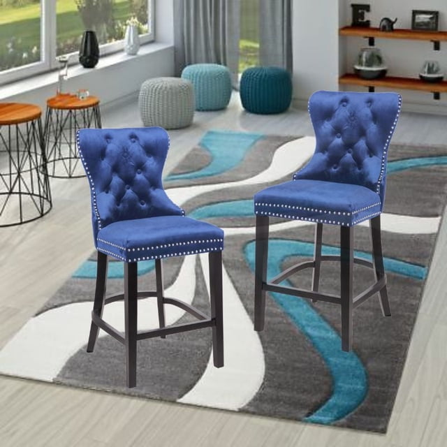 Ley Counter Stool in blue velvet, vintage-style velvet upholstered counter stools with tufted backs and silver nailhead trim, black wooden legs with chrome ring footrest, set of two ideal for kitchen or island counter seating, dimensions 41.5"H x 19.25"W x 24"D.