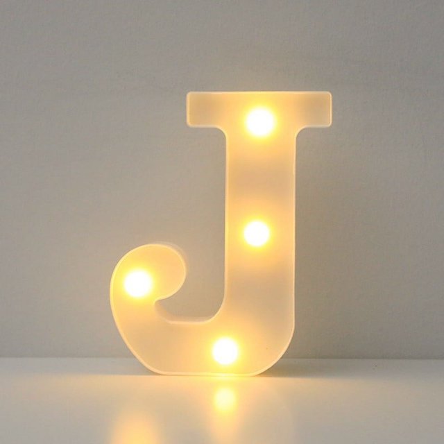 Light Up Letters, LED Marquee Letter Lights Sign in the shape of the letter 'J', illuminated with warm white LED lights. The smooth white finish and evenly spaced bulbs make it suitable for home, party, wedding, or Christmas decoration. This novelty lighting piece is freestanding and can also be wall-mounted, ideal for creating personalized displays.