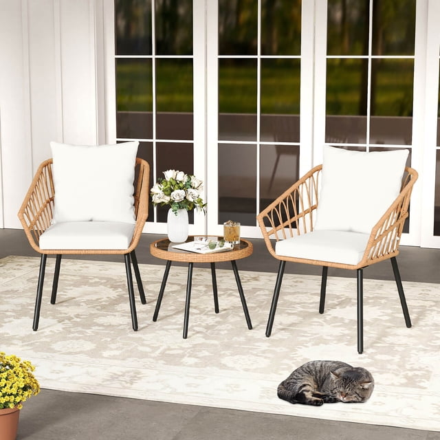 Costway 3 Piece Patio Bistro Set with Heavy Duty Metal Frame for Balcony Garden & Poolside. The set includes two ergonomic chairs with beige cushions and a round table with a tempered glass top. The chairs feature hand-woven brown PE rattan and black metal legs, while the table has a matching rattan frame and suction cups to secure the glass. Ideal for outdoor spaces like patios, gardens, and poolside areas. A cozy and stylish addition to small outdoor spaces.
