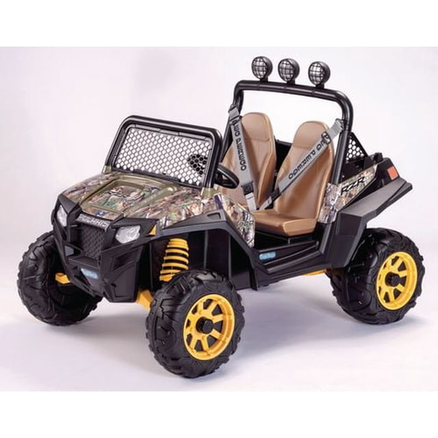 Peg Perego Polaris RZR 900 Camo Toy Vehicle with camo-patterned body, yellow off-road wheels, adjustable tan bucket seats with seat belts, working horn, roll bar with three mounted lights, large cargo bed with tie-down anchors, and 12-volt rechargeable battery included.