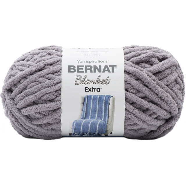 Bernat® Blanket Extra™ Fil jumbo #7 Poids, 10.5oz/300g, 97 yards, chenille en polyester Gris Doux avec texture Peluche Épaisse, Étiquette Montrant une Couverture Tricotée Bleue sur une Chaise beige, Convient à une Déco Maison Chaleureuse et à des Projets Lavables à la machine.