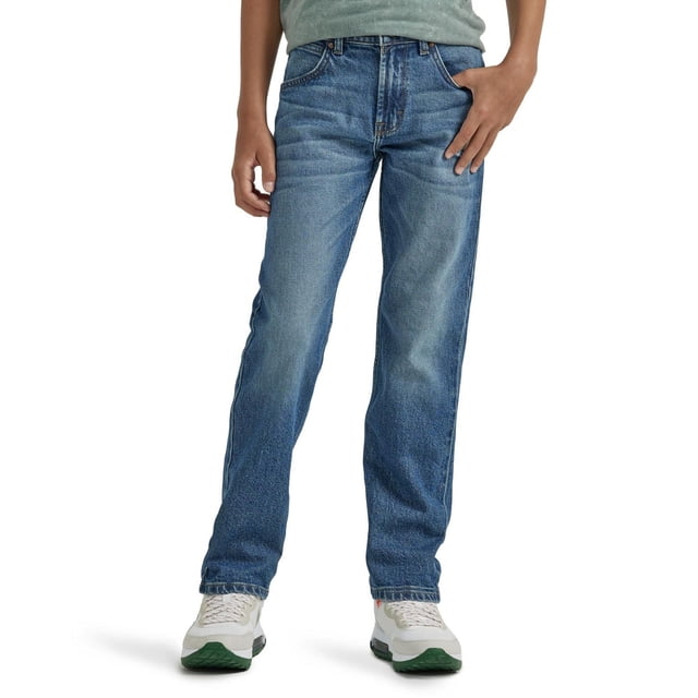 Wrangler jeans Fuselés Décontractés pour Garçon en denim Bleu avec Coupe Décontractée à Travers le Siège et la Cuisse, Ouverture de Jambe Fuselée et Taille Ajustable, Montrés Orientés vers l'Avant sur un Garçon Portant des Espadrilles Blanches et une Chemise Verte, Idéal pour les Garçons Actifs Ayant Besoin de Bas Durables et Résistants à l'Abrasion.