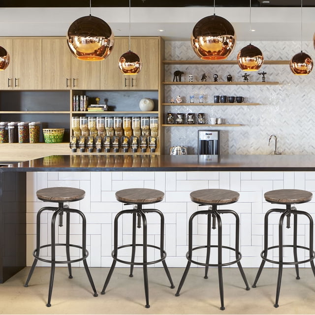 Homy Casa Adjustable Swivel Bar Stool Set of 4 with walnut finish wooden seats and black rust-resistant iron frames, height adjustable from 23 to 30 inches with 360° swivel and footrests, arranged at a kitchen island with white tiled front and wooden countertop, under copper pendant lights, with cereal dispensers and coffee machine in the background, ideal for kitchen or café seating.