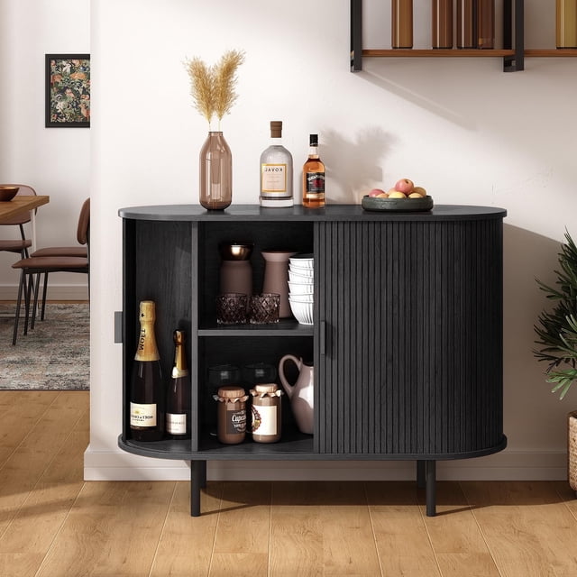MARNUR Sideboard Buffet Cabinet 40-inch black storage cabinet with mid-century modern design, ideal for kitchen, dining, or entryway use. Features two sliding tambour doors with a unique waveform panel, adjustable shelves, and a spacious tabletop for decor or kitchenware. Displayed in a dining room setting with decorative items arranged on top and inside.
