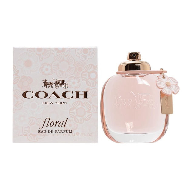 Coach Floral Eau De Parfum Spray For Women 90ml with a clear glass bottle holding light pink perfume, rounded rectangular shape, gold-tone spray cap, and a pink flower charm; shown alongside a floral-patterned box with Coach logo, suitable for joyful daily fragrance use.