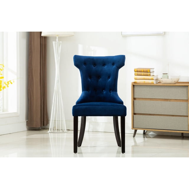 ERICA SET OF TWO ACCENT CHAIRS-BLUE showing a front-facing blue fabric tufted back accent chair with sturdy dark wooden legs and a round handle at the back, placed in a bright living room with a white floor lamp and a wooden dresser with books, ideal for stylish living room seating or occasional use.