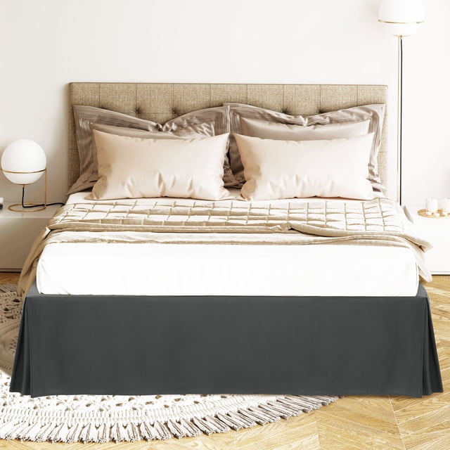 PiccoCasa Bed Skirt Double Brushed Microfiber with Dust Ruffle in Queen size, shown in dark gray. The bed skirt features a 16-inch drop that reaches the floor, concealing under-the-bed storage, frames, or box springs. Made of 110 gsm microfiber, it is wrinkle-resistant, color-fast, and durable. The quadruple pleating design adds elegance, while elastic bands at all four corners ensure a secure fit on the mattress. Displayed in a modern bedroom setting with neutral bedding and decor.