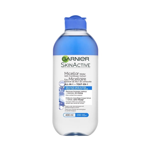 Garnier Micellar Water Makeup Remover All-In-One Cleanser, Delicate Skin & Eyes in a 400 ml clear plastic bottle with a blue flip-top cap, featuring a white label with blue and black text describing its gentle cornflower extract formula that removes longwear makeup and cleanses without rinsing, suitable for daily use and contact lens wearers, often used as a quick facial cleanser for sensitive skin.