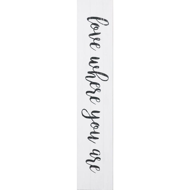 hometrends Distressed Wood Sign Love Where You Are is a vertical wall sign with distressed white wood and black cursive lettering reading 'Love where you are'. It measures 7 inches long by 37 inches wide and is ready to hang, suitable for home décor and wall decoration.