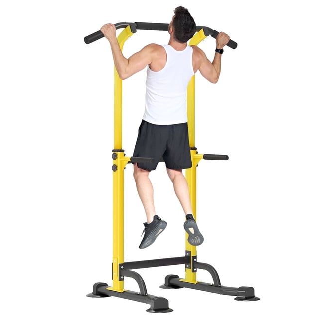SOGES Height Adjustable Power Tower Dip Stands Pull up Bar Strength Training for Home Gym Yellow. A man performs a pull-up on the durable yellow metal frame with adjustable height from 65 to 82.7 inches. This home gym equipment features a widened main bracket, anti-tip base, and versatile grips for exercises like dips, vertical knee raises, and push-ups. Ideal for strength training and full-body workouts targeting shoulders, arms, waist, and legs.