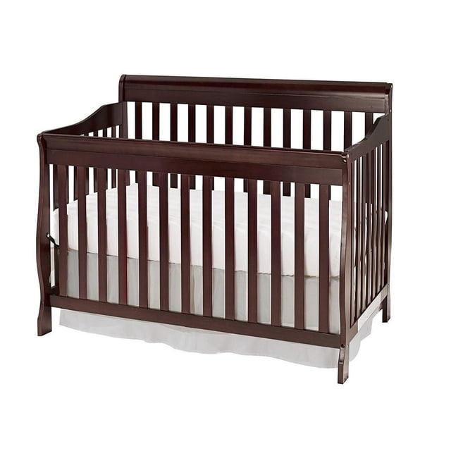 Concord Baby Sara 4-in-1 Crib in dark wood finish with slatted sides and curved top rails, featuring four adjustable mattress heights and a non-toxic finish, shown with white mattress and skirt, designed for nursery use and convertible to toddler and full-size beds with separate rails.