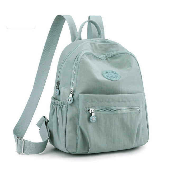 Backpack Women's Large Capacity Versatile Backpack Lightweight Travel Bag in grey. Features a compact design with multiple zippered compartments, adjustable shoulder straps, and side pockets. Suitable for school, travel, or daily use.
