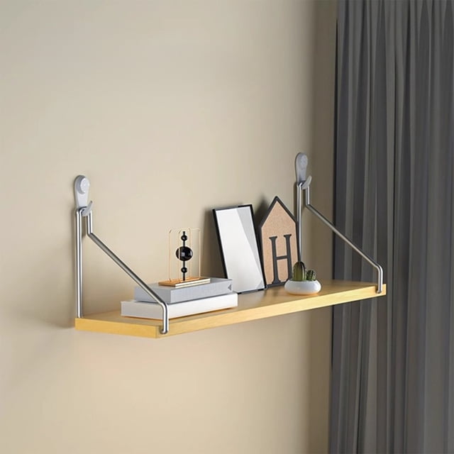 Tyidzon no-drill wall shelf with a yellow wooden surface and silver triangular support brackets, mounted on a beige wall. The shelf measures 30x15cm and is shown holding books, decorative items, and a small potted plant. Designed for versatile use in bedrooms, living rooms, or entryways, it features a hassle-free installation with adhesive strips and damage-free nails, supporting up to 30 pounds.
