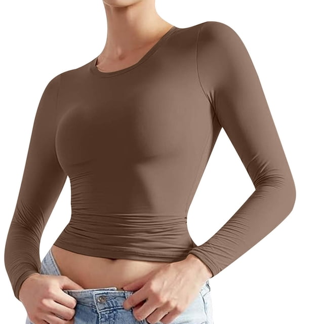 Timegard women's crew neck long sleeve solid color basic tee in a slim fit design. The top is shown in a medium size, featuring a clean silhouette and a fitted style, ideal for layering with cardigans, jackets, or coats. The fabric appears soft and breathable, suitable for casual wear in fall, spring, or summer. The model pairs the top with light blue jeans, showcasing its versatility for pairing with various bottoms.