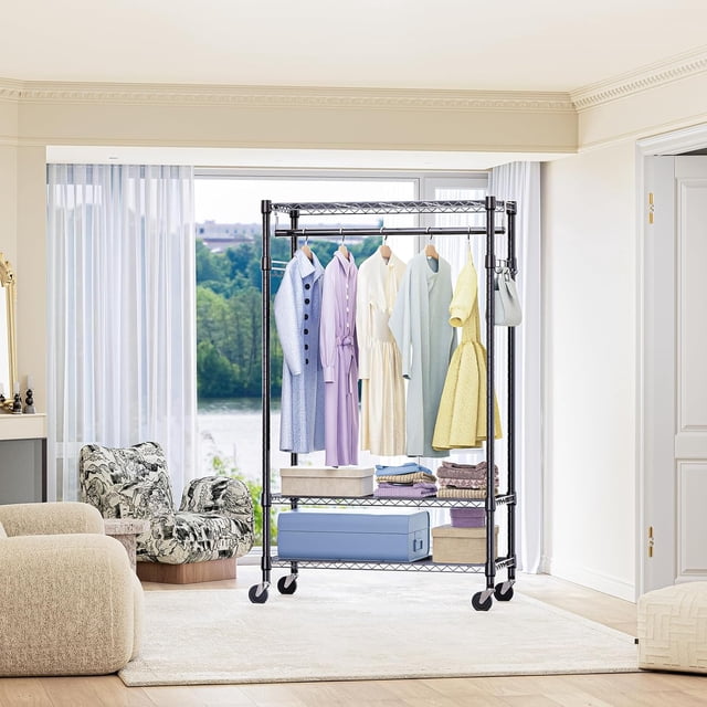 M MZG Garment Rack Adjustable with Hanging Rod, a black rolling closet organizer with wheels, featuring a durable carbon steel frame with anti-rust coating. It includes three adjustable wire shelves, a sturdy hanging rod, and side hooks for versatile storage of clothes, shoes, and accessories. Measuring 15.7 inches deep, 29.5 inches wide, and 74.5 inches high, it supports up to 750 lbs on stationary feet and 300-350 lbs on wheels. The rack is shown in a bright, modern living space with clothing, boxes, and folded items neatly organized.