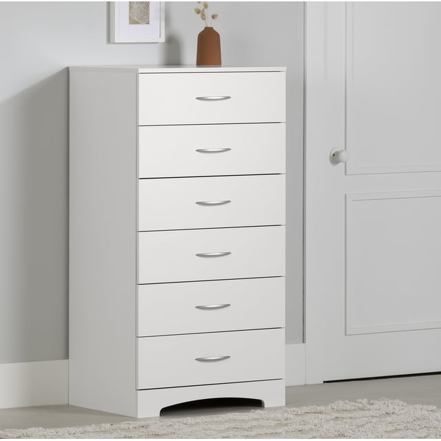 South Shore Step One Commode à 6 Tiroirs pour Adulte en Blanc Pur avec six Tiroirs et Poignées en Métal, Présentant une Plaque à Pousser Courbée, Apparaissant Face vers l'Avant contre un Mur Gris Pâle et une Porte Blanche, Conçue pour un Rangement compact dans la Chambre et Adaptée à l'Organisation de Vêtements, de Linge Ou de Jouets.