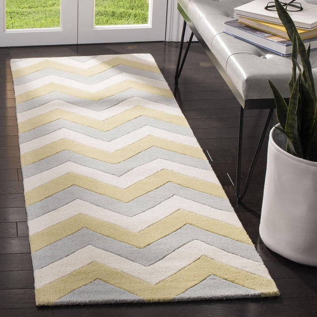 Safavieh Chatham Jake Tapis à Rayures Zigzag avec Laine Tuftée à la Main et Hauteur de Poil Moyenne, Affichant un Motif Zigzag à Rayures Jaune Doux, Gris Pâle et Blanc Cassé, Placé sur un Plancher de Bois Franc Foncé à Côté d'Un Banc Moderne et d'Un Cache-Pot Blanc avec une Plante Verte, Convient pour Améliorer le Confort et le style dans les Espaces de Vie Contemporains.