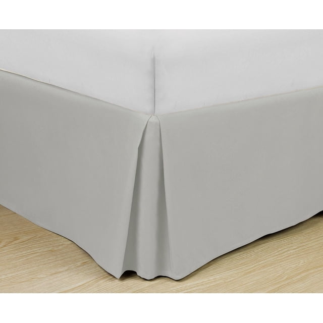 Jupe de Lit en Microfibre Super Douce, Gris Pâle Uni avec Détail Plissé en Caisson et Retombée de 14 Pouces sur Trois Côtés, Fabriquée en Microfibre Résistante aux Plis et à la Décoloration, Montrée Ajustée sur un Coin de Lit sur un Plancher de Bois Clair, Souvent Utilisée pour Donner aux Lits un Style Ajusté et Fini.