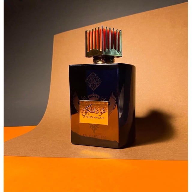 Oud Malaki / عود ملكي Parfum Arabe Unisexe par HSA Perfumes Présenté dans une Bouteille Sombre et Élégante avec Détails Dorés et un Capuchon Métallique Décoratif. le Parfum Est Conçu pour une Tenue Longue Durée, avec des notes Équilibrées de Dessus, de Milieu et de base. la Bouteille s'Inscrit dans un Fond Chaud et Dégradé, Mettant en Valeur Son Attrait Luxueux.