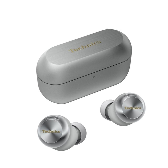Technics EAH-AZ100 Reference Class True Wireless Noise Cancelling Earbuds in silver, shown with a matching compact charging case. The earbuds feature a sleek, ergonomic design with a metallic finish and the Technics logo on the outer surface. The charging case has a brushed aluminum texture and a gold Technics logo on the lid. These earbuds offer advanced features like adaptive noise cancelling, Dolby Atmos support, and Voice Focus AI for clear calls. They are lightweight, water-resistant, and provide up to 10 hours of playback on a single charge, with an additional 28 hours from the case.
