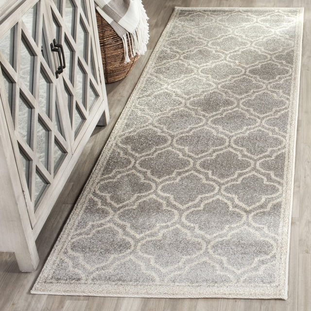 Safavieh Amherst Wilson Tapis Géométrique pour Aire, un Coureur durable Intérieur-Extérieur en Polypropylène avec un Motif de Treillis Géométrique Gris et Crème, Placé sur un Plancher de Bois Clair à Côté d'Une Armoire Grise avec des Portes à Panneaux de Verre et un Panier Tressé avec un Jeté à Franges, Idéal pour les Zones à Fort Passage.