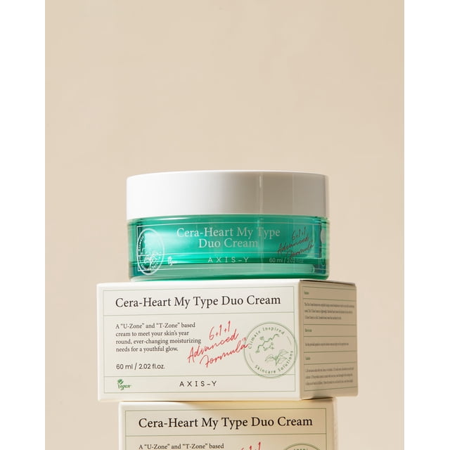 AXIS-Y Cera-Heart My Type Duo Cream, un Hydratant pour le Visage 2-en-1 Conçu pour une Hydratation Ciblée de la T-zone et de la U-zone. le Produit Présente un Pot Vert avec un Couvercle Blanc, Placé sur le Dessus de Ses Boîtes d'Emballage. Formulé avec de l'Extrait de heartleaf, des Céramides, du Sorgho et de l'Allantoïne, Il Offre un Contrôle de l'Huile, une Hydratation Longue Durée et des Bienfaits pour l'Éclaircissement de la Peau