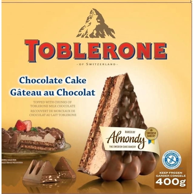 Toblerone Gâteau au Chocolat Montrant une Tranche Triangulaire avec base d'Amande, Crème au Chocolat Riche et Couches de mousse au Chocolat au Lait, Surmonté de Morceaux de Chocolat au Lait Toblerone, sur un Fond Doré avec Texte Bilingue Anglais et Français et une Étiquette de Boulangerie Surgelée de 400 g.