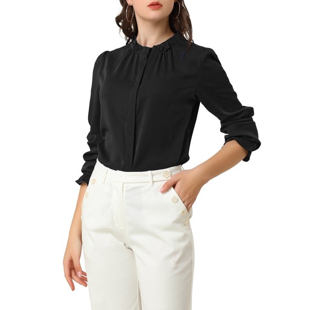 INSPIRE CHIC Women's Ruffled Trim Button Down Stand Collar Long Sleeve Blouse Top in size S and black color. This lightweight chiffon blouse features a stand collar, ruffled neckline, and long sleeves with ruffled cuffs. The hidden placket adds a sophisticated touch, while the solid black color makes it versatile for business, casual, or evening wear. Shown paired with white high-waisted trousers.