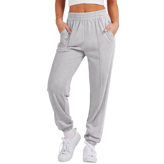 Women Sports Pants Trousers Jogging Sweatpants Jogger Pants in grey color, made of durable polyester material. Features an elastic waistband, side pockets, and a tapered leg design. Ideal for casual occasions, women's sweatpants styled with white sneakers and a cropped top.