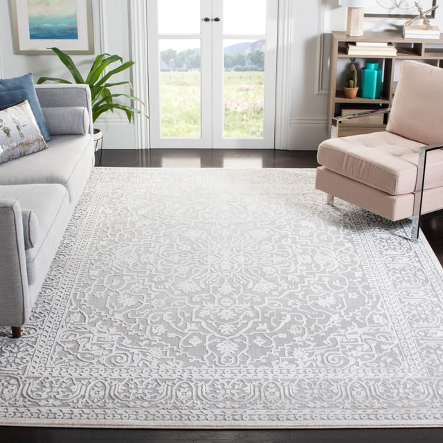 Safavieh Reflection Dolkar Traditional Area Rug in light grey and cream with an intricate etched floral and geometric pattern in high and low pile, power loomed with polyester and polypropylene, placed in a living room between a grey sofa and beige armchair on dark hardwood floors near glass double doors, ideal for combining vintage style with modern durability.