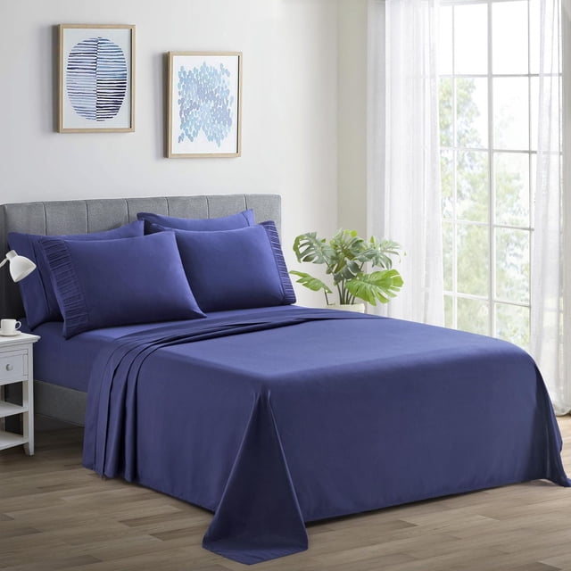 Marina Decoration Ultra Soft Silky Deep Pocket Solid Rayon from Bamboo Bedding All Season Sheet Set in navy blue on a bed with a grey upholstered headboard, featuring pleated pillowcases and smooth fitted and flat sheets in a bright room with wooden floor, white nightstand, green plant, and blue abstract framed art, suitable for all-season comfort and breathable sleep.