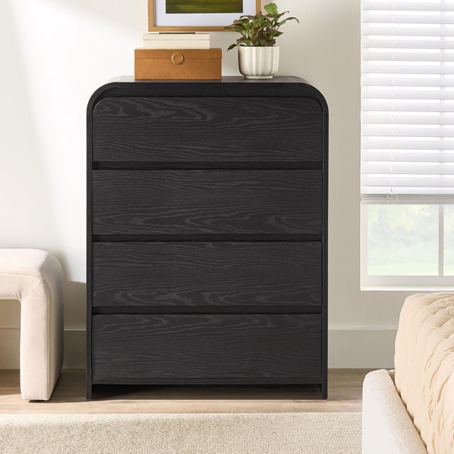 Better Homes & Gardens Commode Juliet à 4 Tiroirs, Fini Grain de Bois Noir Riche, avec Tiroirs à Glissement Fluide et Bords Arrondis, Convient au Rangement des Meubles de Chambre et à l'Organisation des Vêtements, Présentée dans une Pièce Lumineuse avec Sièges Beiges et une Fenêtre avec Stores Blancs.